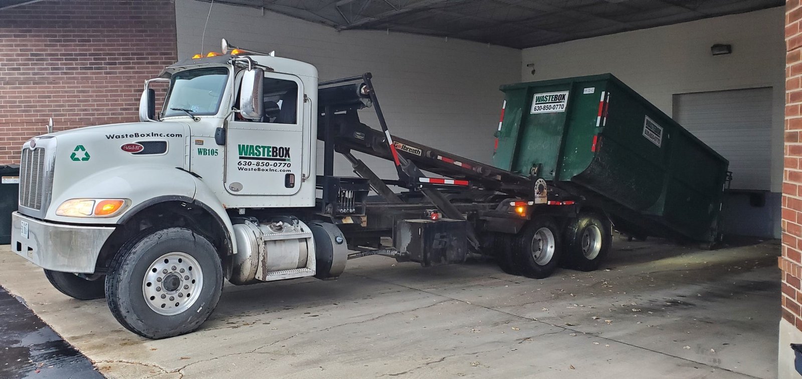 WasteBox truck WB105 placing a container at a commercial loading bay